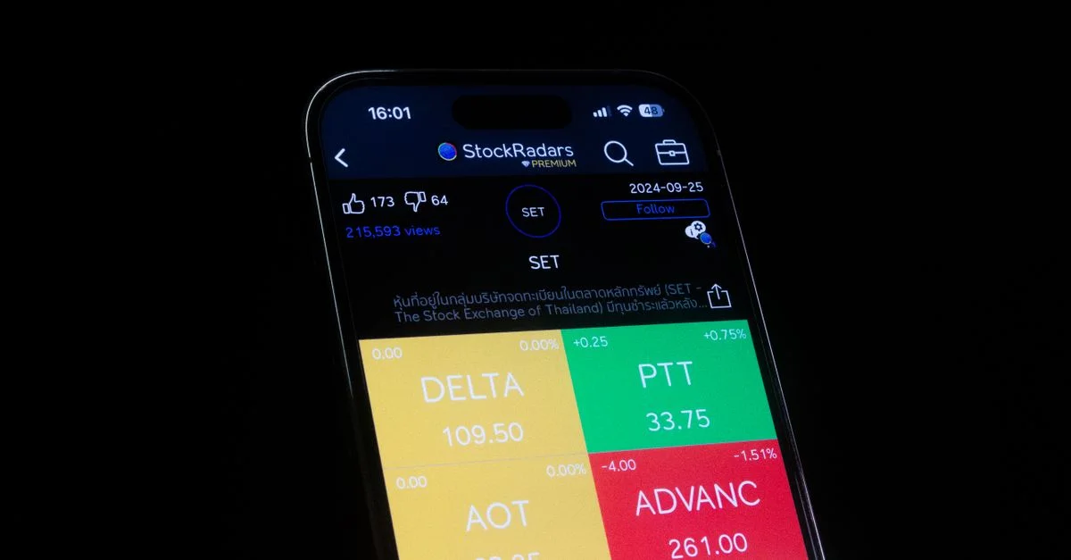 Gros plan sur un smartphone affichant des données boursières sur l'écran d'une application financière.