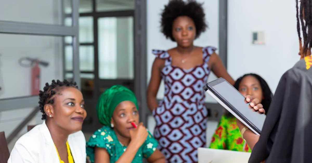 Équipe diversifiée de femmes africaines collaborant lors d'une réunion de bureau.