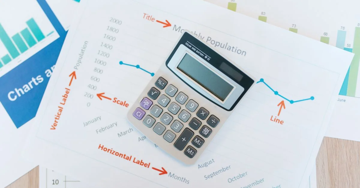 Calculatrice placée sur des graphiques financiers et des rapports montrant l'analyse des données et la documentation d'entreprise.