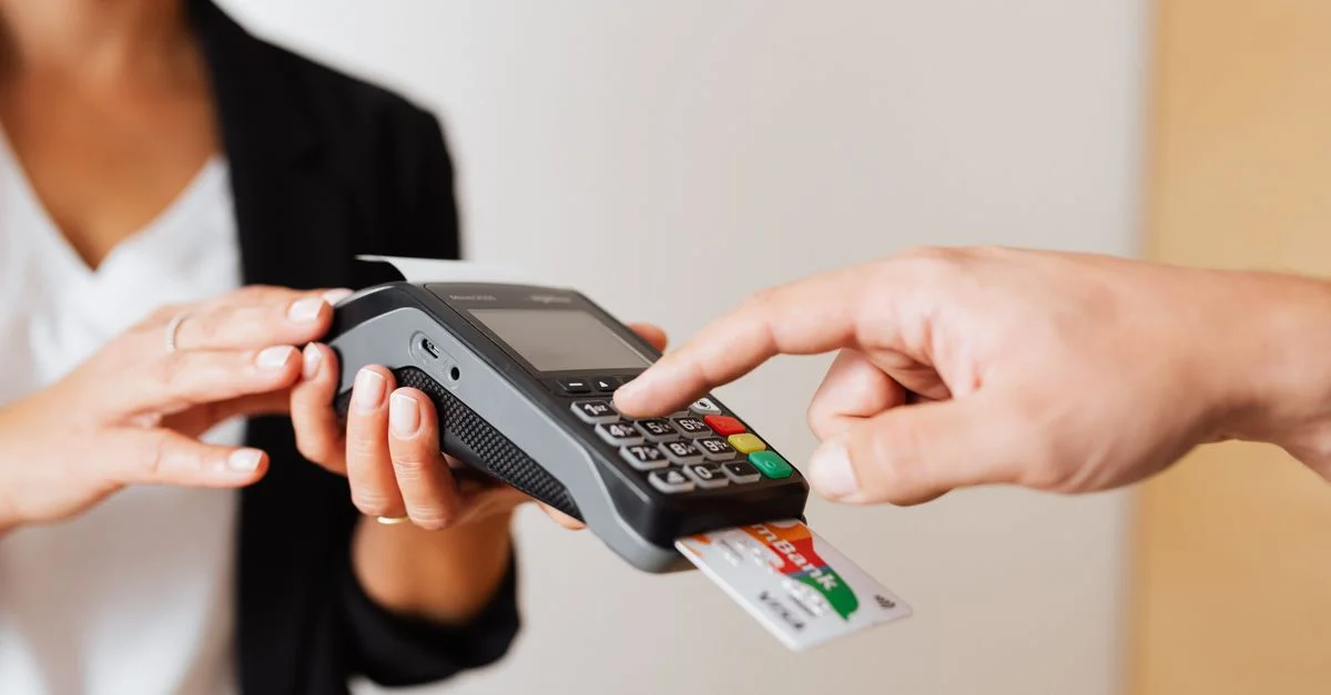 Un client utilisant un terminal de paiement sans contact pour des transactions sécurisées et sans espèces à l'intérieur.