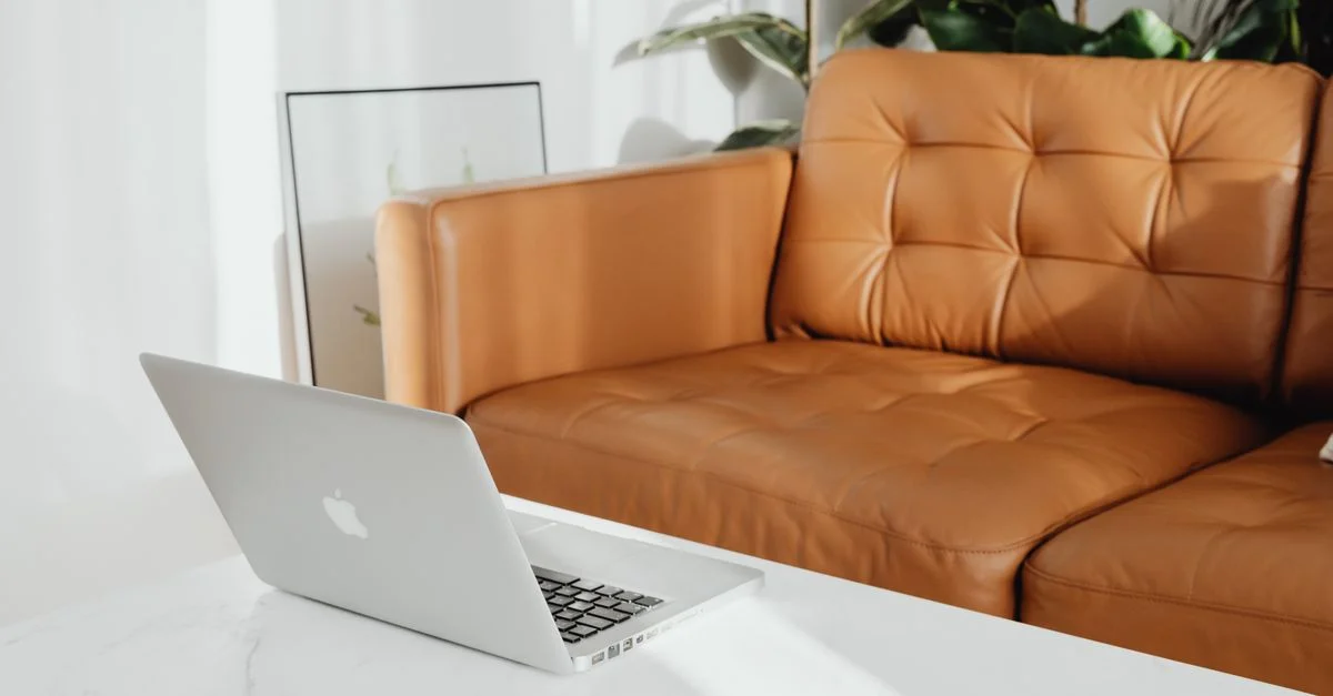 Un salon cosy avec un ordinateur portable sur la table basse, idéal pour se détendre.