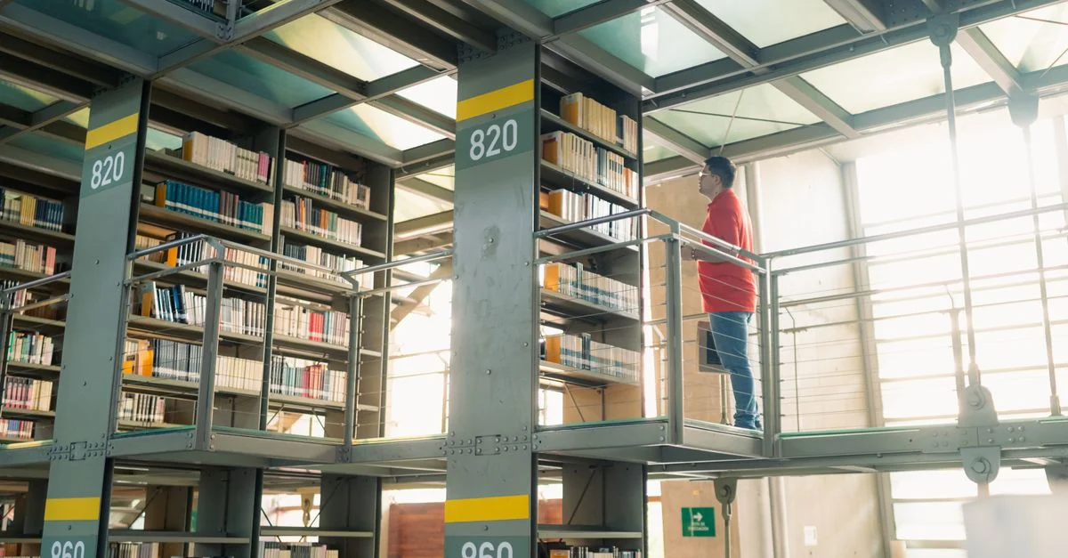 Un étudiant parcourt les étagères d'une bibliothèque moderne à Mexico