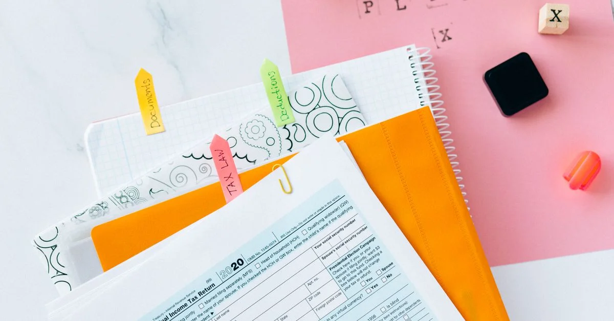 Vue aérienne de documents fiscaux, formulaires et d'un espace de travail organisé pour la préparation des impôts.