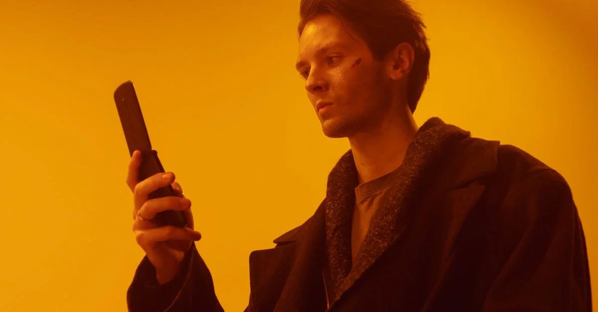 Portrait de studio dramatique d'un homme utilisant un téléphone à clapet vintage.