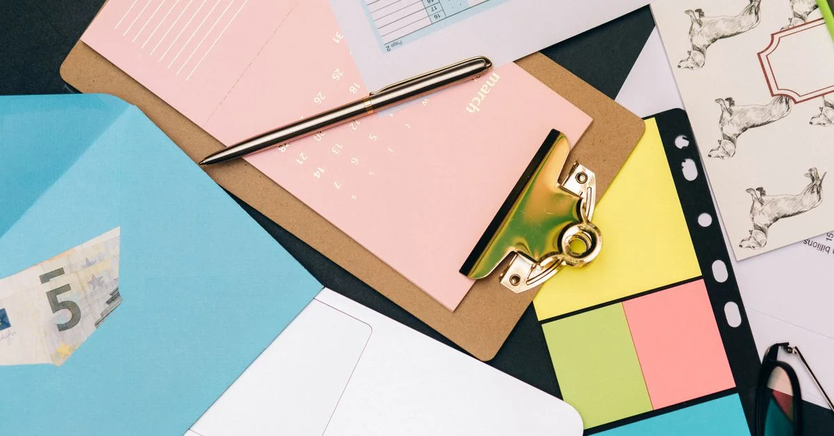 Fournitures de bureau soigneusement arrangées avec un plateau, un billet en euros et des notes colorées.