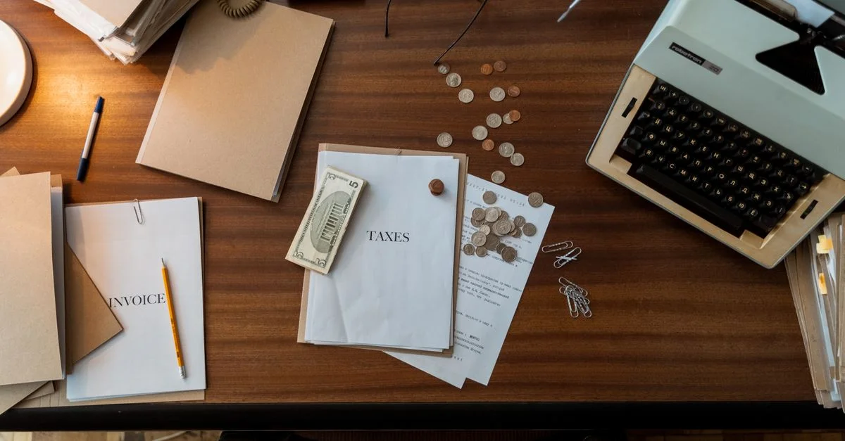Scène de bureau rétro avec une machine à écrire, des pièces de monnaie, des documents et des fournitures de bureau sur un bureau en bois.