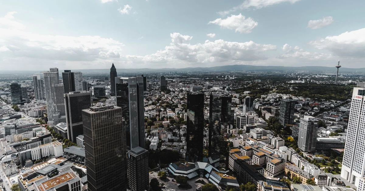 Vue aérienne époustouflante mettant en valeur la skyline de Francfort avec des gratte-ciels modernes et un ciel bleu clair.