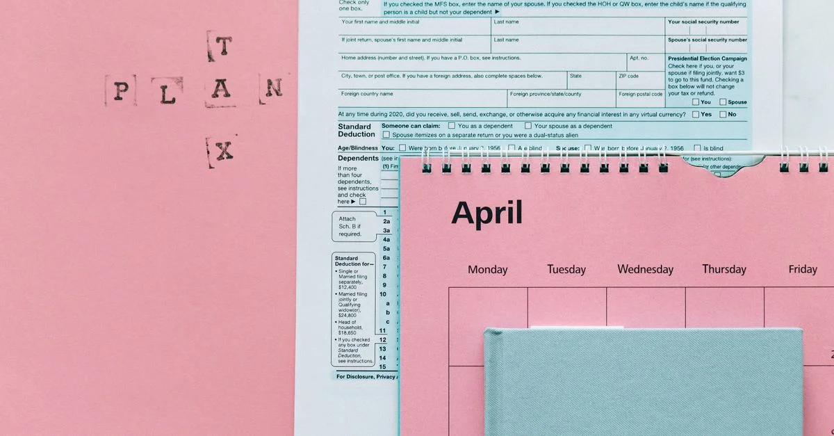 Articles liés aux impôts sur fond rose, y compris des formulaires et un calendrier.